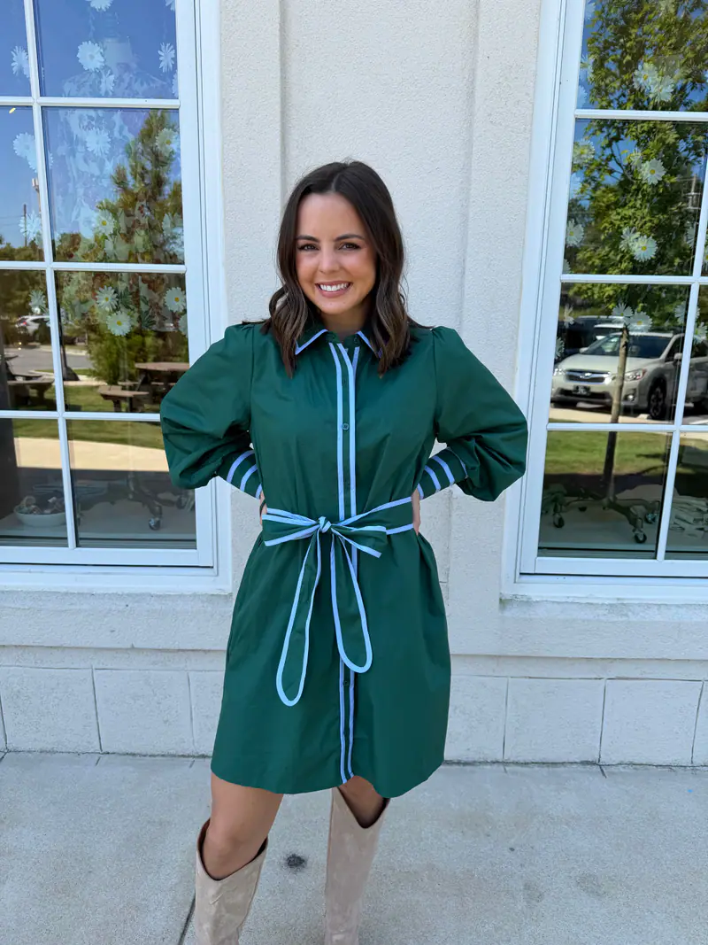 Madison wearing a hunter green mini dress with blue accents